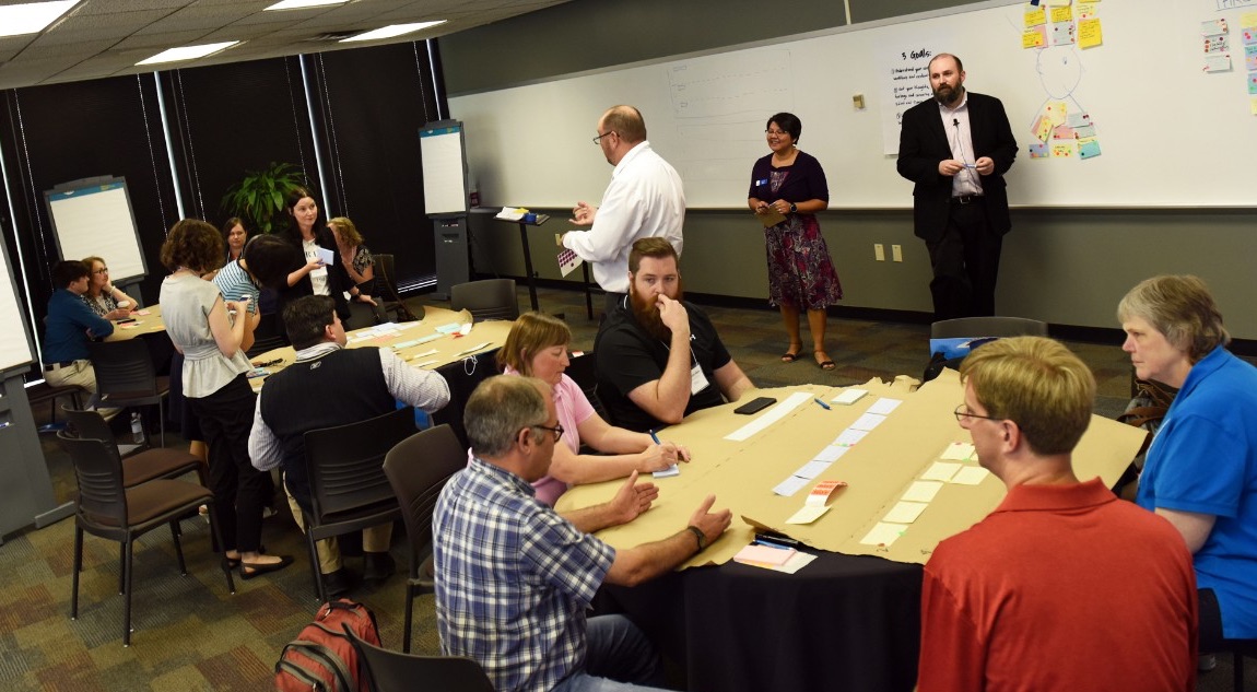 Photo of Edward Stull leading a design thinking session with a large group of participating library representatives